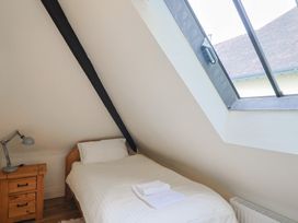 A bedroom with a bed and lamp at Yard Cottage in Rousdon