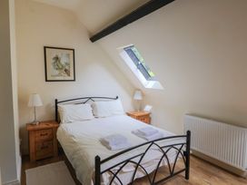 A bedroom with a bed and nightstands at Yard Cottage in Rousdon
