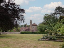 A building with a tower and greenery at Yard Cottage in Rousdon