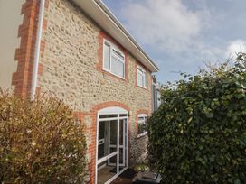 An exterior view of a house with a stone wall and shrubbery at Greystones Lyme Regis