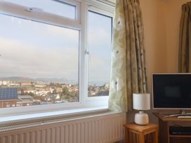 A living room with a television and a view through the window at Greystones Lyme Regis