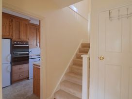 A kitchen with wooden cabinets and a staircase at Greystones Lyme Regis