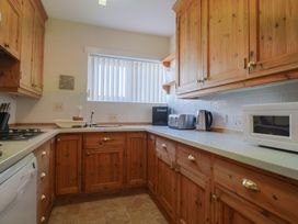 A kitchen with wooden cupboards and appliances at Greystones in Lyme Regis