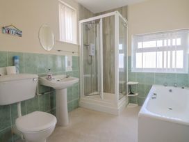A bathroom with shower, bathtub, toilet and sink at Greystones Lyme Regis