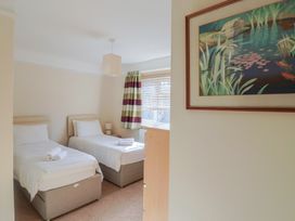 A bedroom with twin beds and a painting at Greystones in Lyme Regis