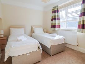 A bedroom with two single beds and a window at Greystones Lyme Regis