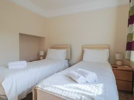 A bedroom with two single beds and a nightstand at Greystones Lyme Regis