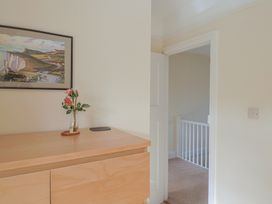 A hallway with a cupboard and a vase of flowers at Greystones Lyme Regis