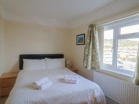 A bedroom with a bed and window at Greystones Lyme Regis