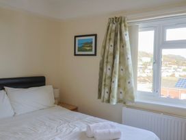 A bedroom with a bed and window at Greystones in Lyme Regis