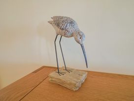 A bird sculpture on a wooden surface at Greystones in Lyme Regis