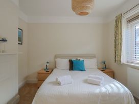 A bedroom with a bed and bedside tables at Greystones Lyme Regis