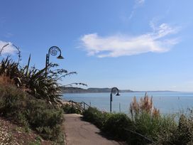 A pathway overlooking the ocean with lamp posts and plants at Greystones Lyme Regis