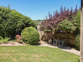 A garden with bushes and patio furniture at Greystones in Lyme Regis