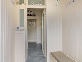 A hallway with a clock and wall hooks at 2 Hadleigh Villas in Lyme Regis
