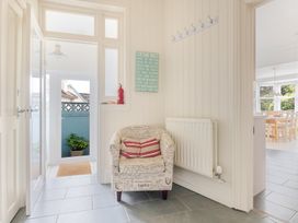 A hallway with a chair and hooks at 2 Hadleigh Villas in Lyme Regis