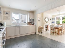 A kitchen with cabinets and a dining area at 2 Hadleigh Villas Lyme Regis