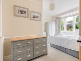 A bedroom with a dresser, bed and wardrobe at 2 Hadleigh Villas in Lyme Regis