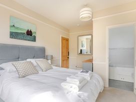 A bedroom with a bed and artwork on the wall at 2 Hadleigh Villas in Lyme Regis