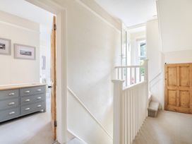 A hallway with a staircase and a dresser at 2 Hadleigh Villas Lyme Regis