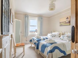 A bedroom with two beds and a window at 2 Hadleigh Villas in Lyme Regis