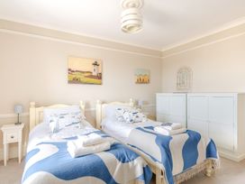 A bedroom with two single beds and a wardrobe at 2 Hadleigh Villas Lyme Regis