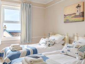 A bedroom with two beds and a window at 2 Hadleigh Villas Lyme Regis
