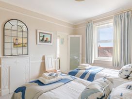A bedroom with two beds and a mirror at 2 Hadleigh Villas in Lyme Regis