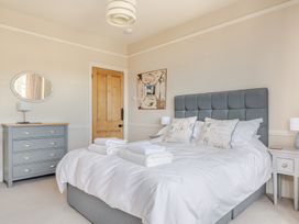 A bedroom with a bed and dresser at 2 Hadleigh Villas in Lyme Regis