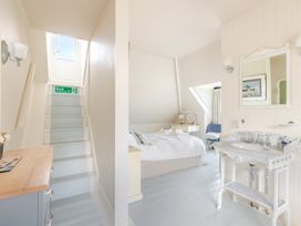 A bedroom with a bed, mirror, and stairs at 2 Hadleigh Villas in Lyme Regis