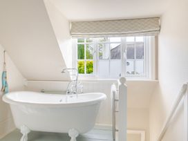 A bathroom with a bathtub and window at 2 Hadleigh Villas in Lyme Regis