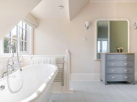 A bathroom with a bathtub and dressing table at 2 Hadleigh Villas in Lyme Regis