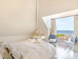 A bedroom with a window opening to a view at 2 Hadleigh Villas Lyme Regis