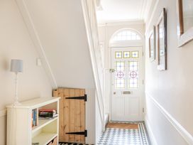 A hallway with a front door and staircase at 2 Hadleigh Villas in Lyme Regis