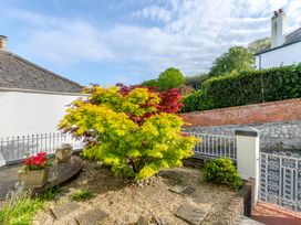 A garden with a maple tree and flower pots at 2 Hadleigh Villas Lyme Regis