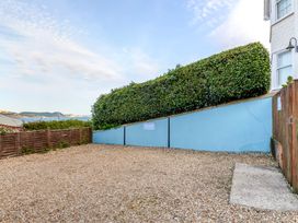 A parking area with gravel surface and greenery at 2 Hadleigh Villas in Lyme Regis