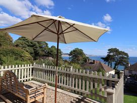 An outdoor space featuring an umbrella and bench at Westhaven in Lyme Regis