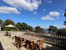An outdoor terrace with a table and chairs at Westhaven in Lyme Regis
