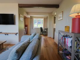 A living room with a television and bookshelf at Westhaven in Lyme Regis