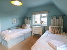 A bedroom with two beds and a dresser at Westhaven in Lyme Regis