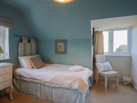 A bedroom with a bed and a chair at Westhaven in Lyme Regis