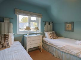 A bedroom with two beds and a dresser at Westhaven in Lyme Regis