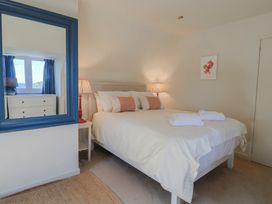 A bedroom with a bed and a mirror at Westhaven in Lyme Regis