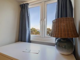 A bedroom with a window and lamp at Westhaven in Lyme Regis