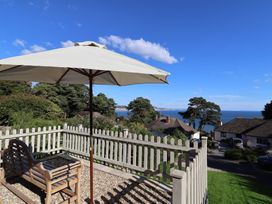 An outdoor space with a bench under an umbrella at Westhaven in Lyme Regis