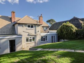 The side view of a house with a lawn at Westhaven Lyme Regis