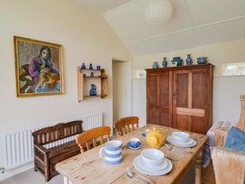 A dining room with a table set for tea at Penny Plot Cottage in Lyme Regis