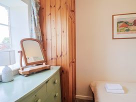 A bedroom with a mirror and lamp at Penny Plot Cottage in Lyme Regis