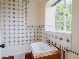 A bathroom with a bath tub and window at Penny Plot Cottage Lyme Regis