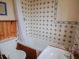 A bathroom with a bathtub and a toilet at Penny Plot Cottage in Lyme Regis